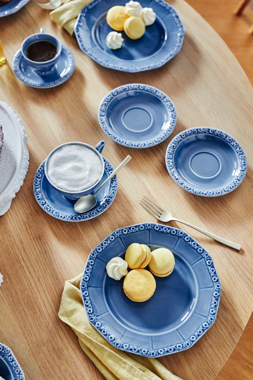 Wooden table set with different plates and cups